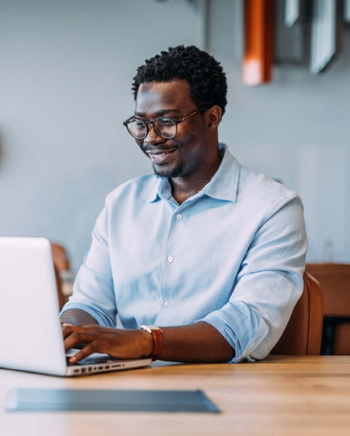 Homme souriant qui travaille sur un ordinateur portable