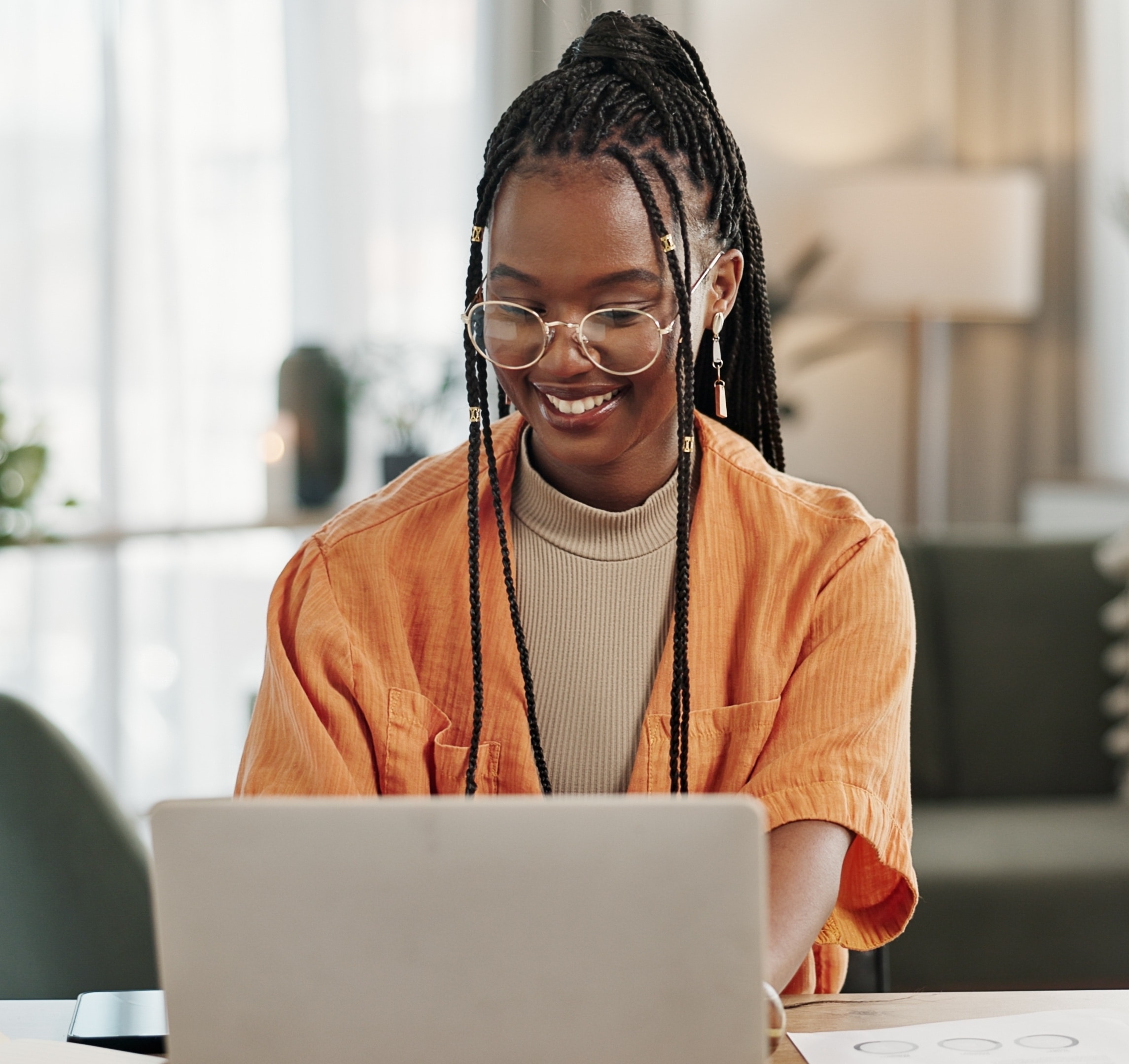 Jeune femme souriante qui travaille sur un ordinateur portable